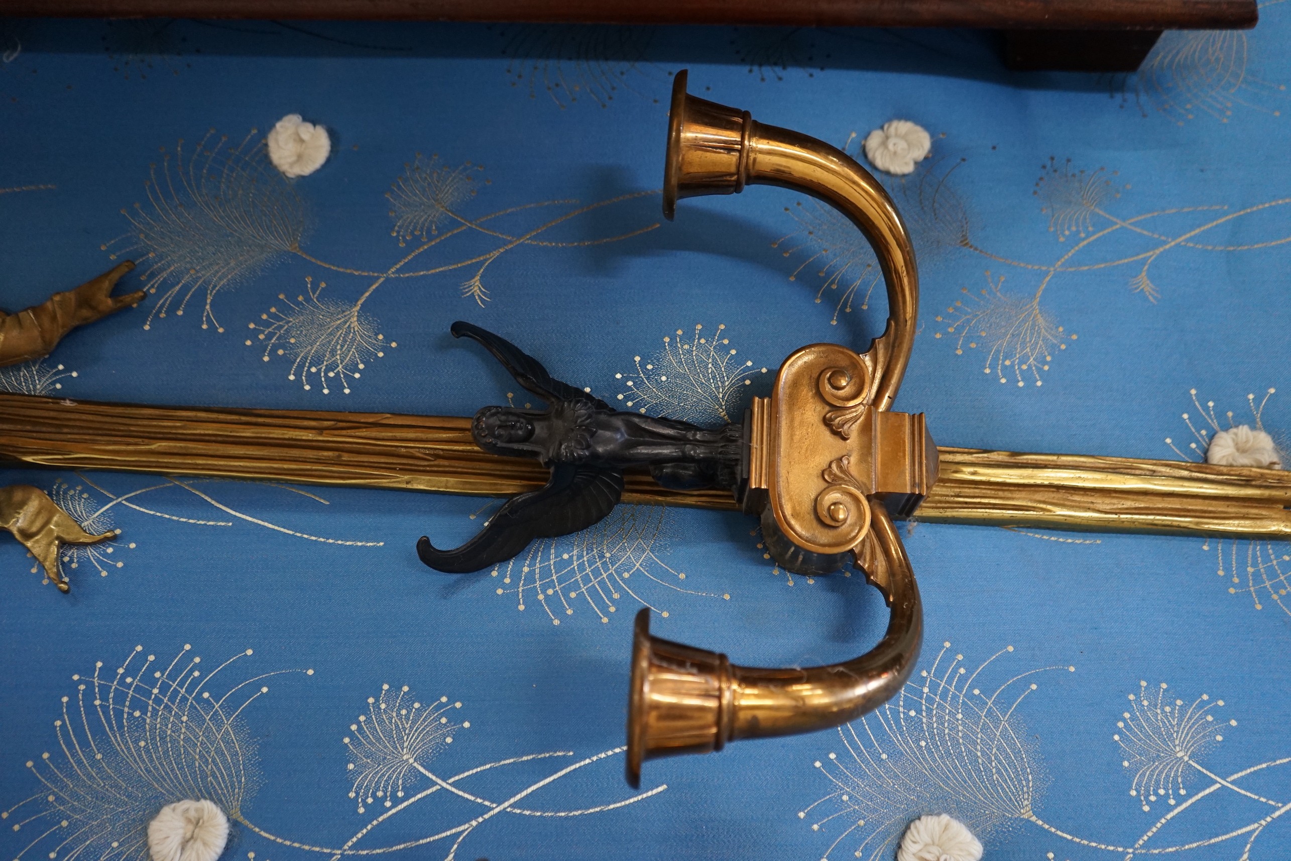 A pair of bronzed and gilt metal Empire style twin branch ribbon fold wall lights, height 95cm